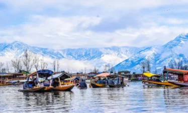 Dal Lake Srinagar me shikara boats and snow mountains ka scenic view”