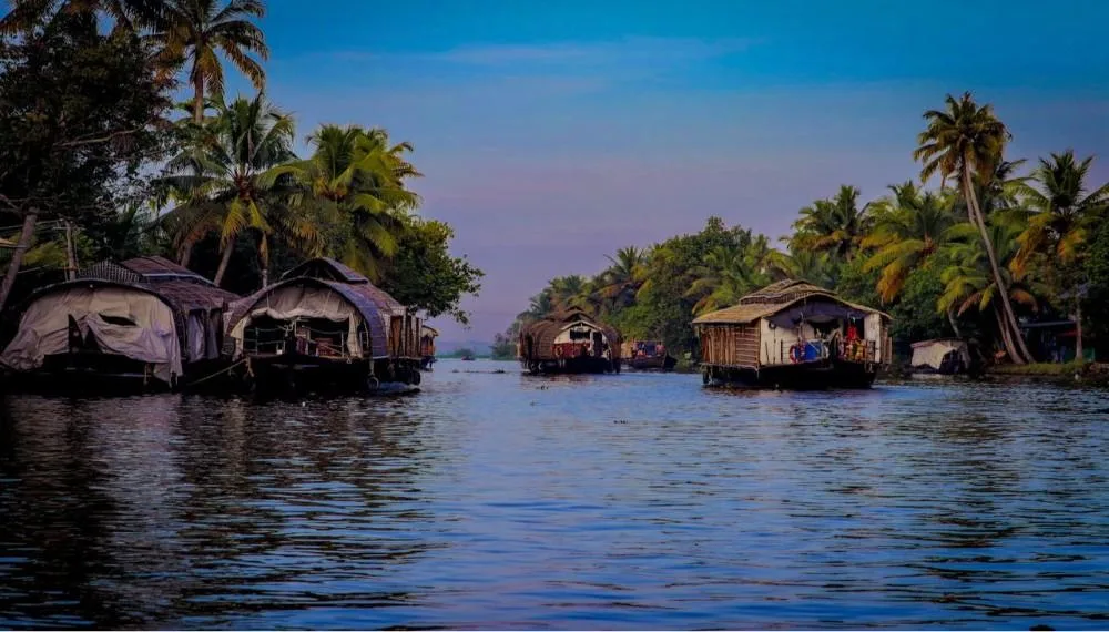 Best honeymoon places in India in December“Houseboats floating peacefully on backwaters surrounded by coconut trees in Alleppey, Kerala”