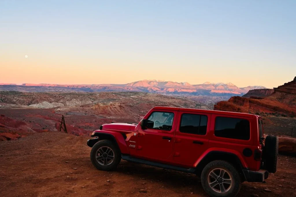 Red Jeep exploring Moab Utah desert landscape in best places to visit in june usa guide