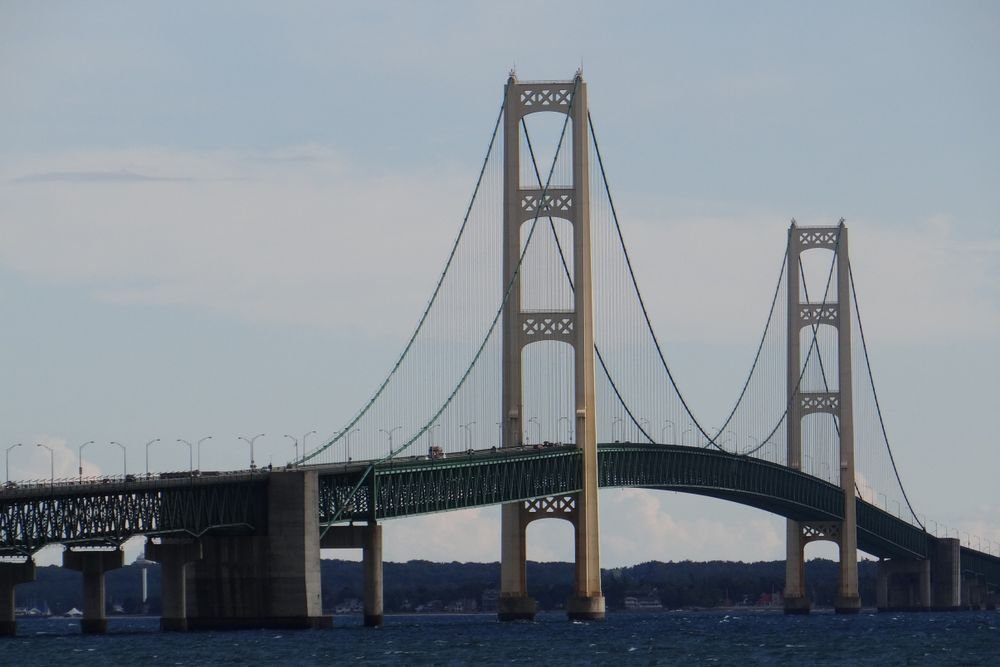 The iconic Mackinac Island bridge framing the blue waters, showcasing one of the best islands to visit in August in the USA.