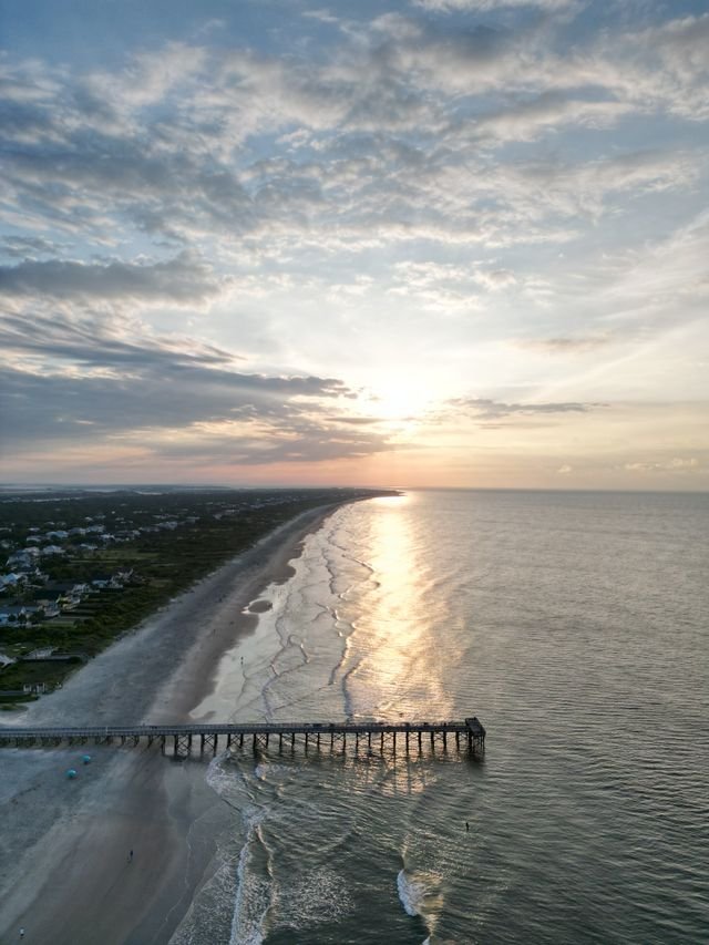 Aerial drone view of the coastline and ocean at Tybee Island Georgia during golden hour sunset.