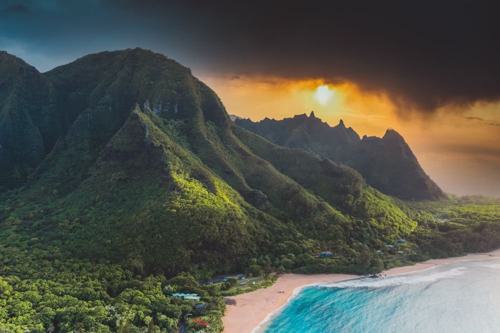Dramatic green volcanic mountain peaks at sunset in Kauai, a top choice among the best islands to visit in july.