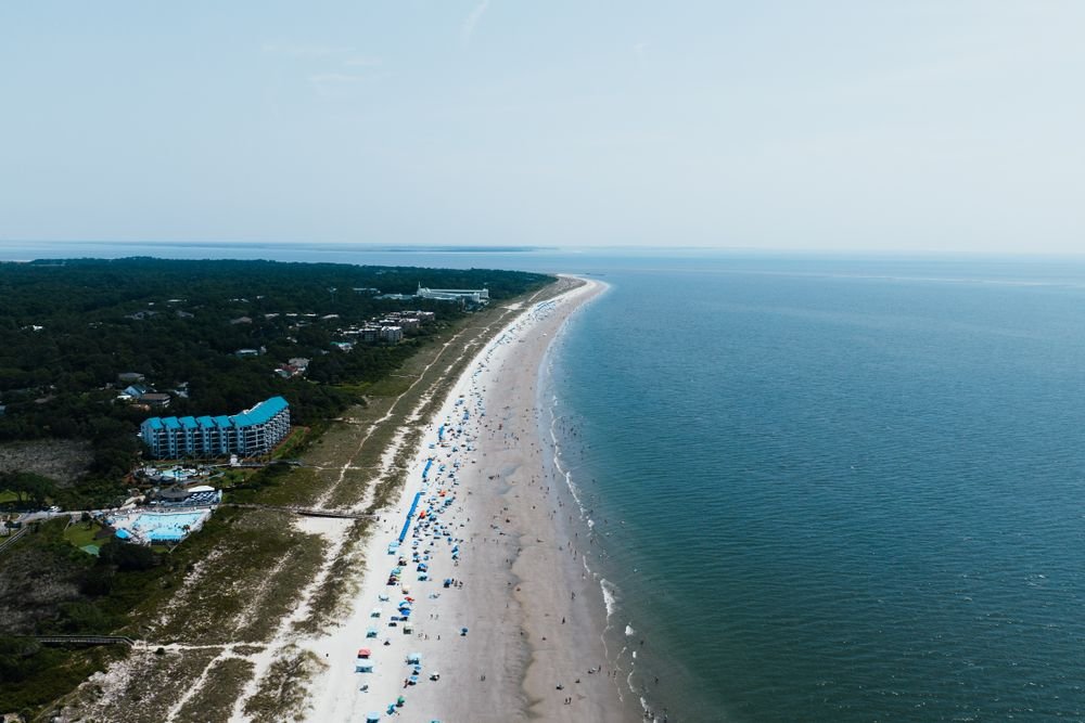Aerial drone view of the expansive white sand shoreline at Hilton Head Island, one of the best beaches to visit in july.