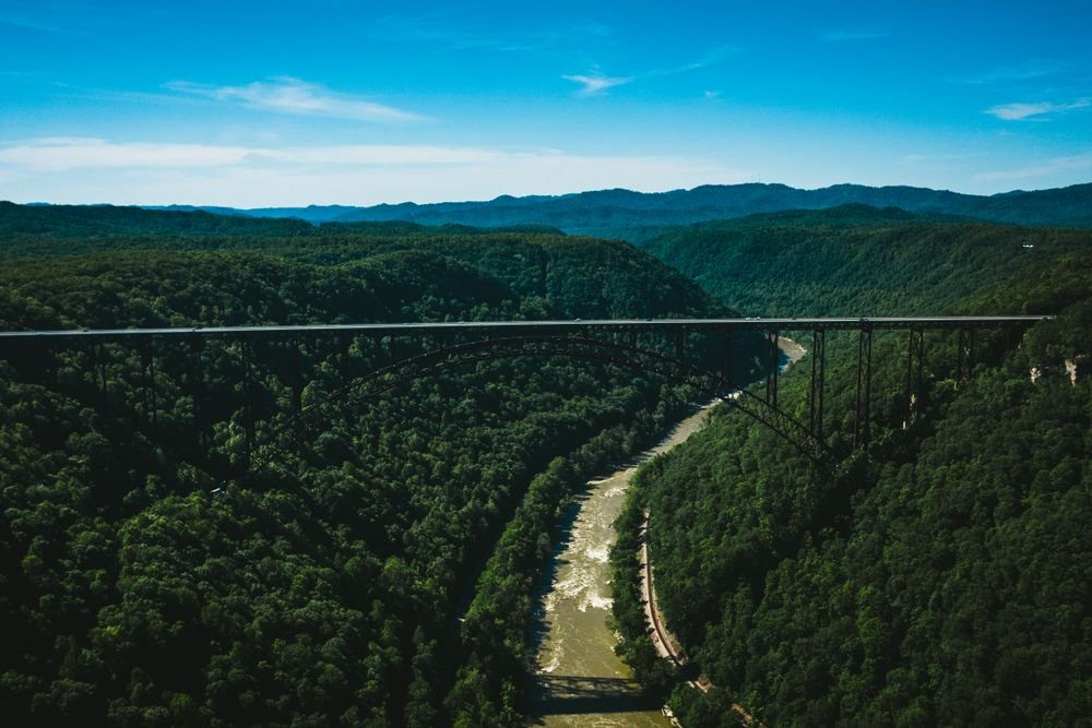 The iconic New River Gorge Bridge stretching across the deep green canyon and river, featured among the best national parks to visit in September.