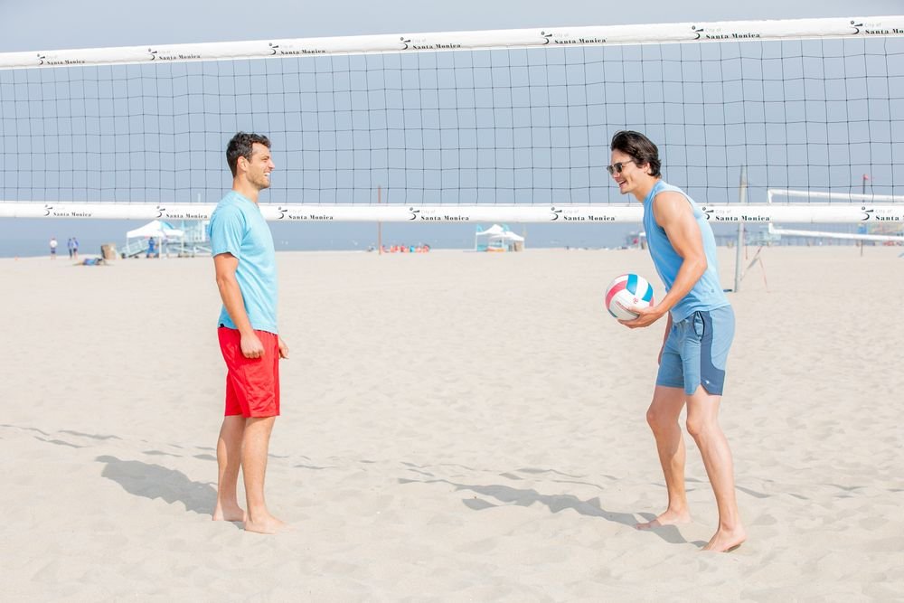 Friends playing volleyball on one of the best beaches to visit in august across the USA.
