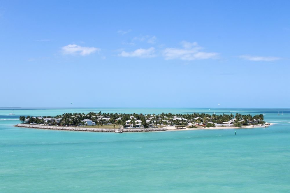 A scenic view of a private island resort in Key West surrounded by turquoise waters, making it one of the best islands to visit in August.