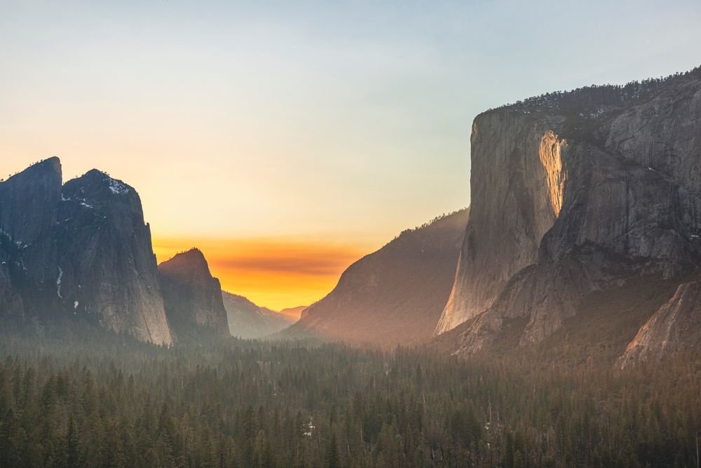 Golden sunset light illuminating El Capitan and Half Dome at Yosemite, one of the best national parks to visit in September.