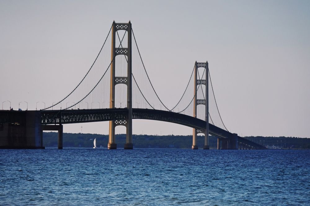 Iconic suspension Mackinac Bridge over the blue water leading to Mackinac Island, one of the best islands to visit in july.